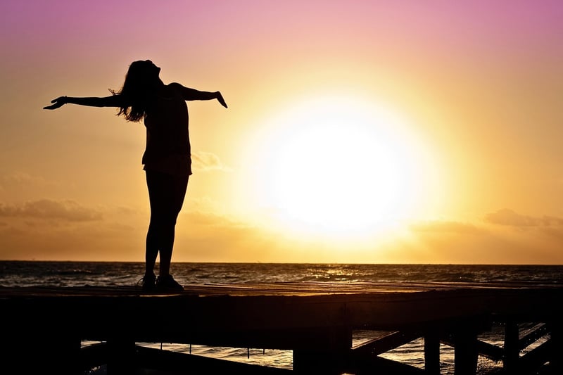 Silhouette of a person on top of a mountain